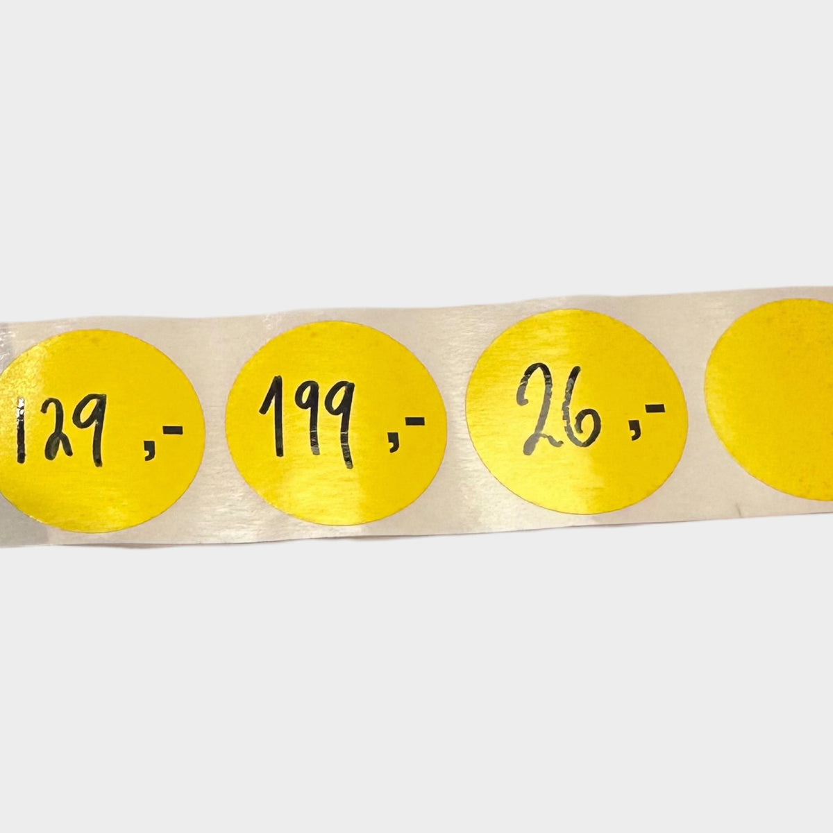 Yellow labels pre-printed ',-' / 1,000 pcs per roll.
