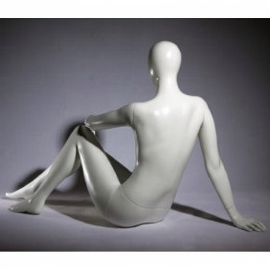 Faceless female mannequin. White, matte with faceless head. Seated